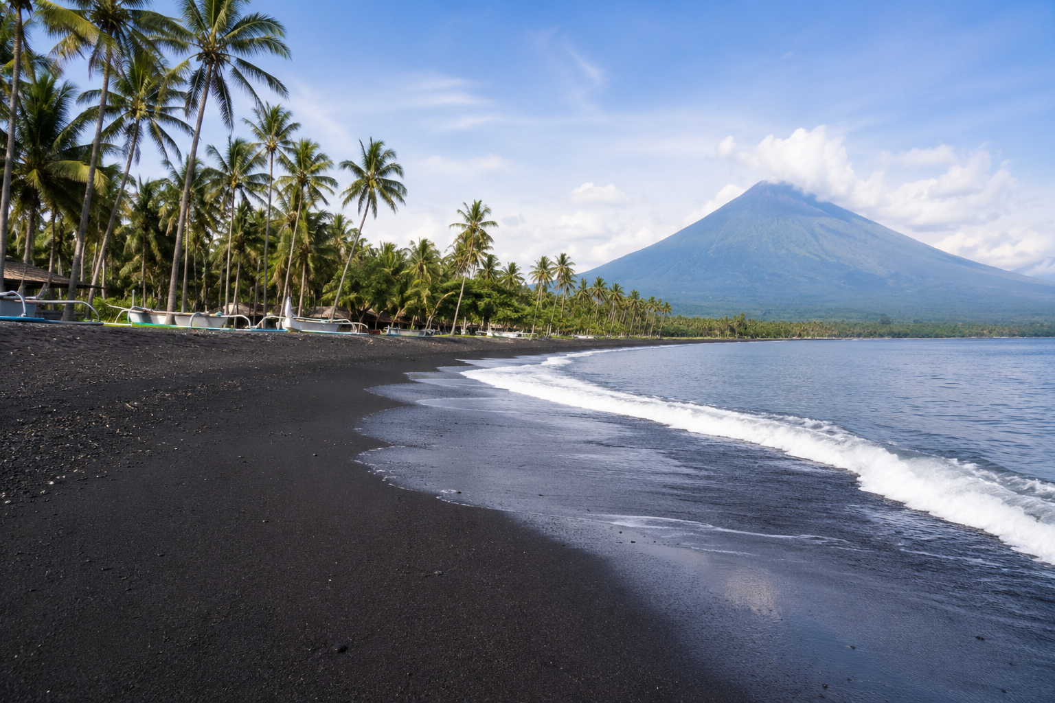 Pantai Pasir Hitam Indonesia dengan hamparan pasir vulkanik berwarna hitam, ombak yang tenang, serta pemandangan laut dan perbukitan yang indah.